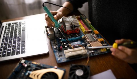 Close up of a woman hands repairing computer.